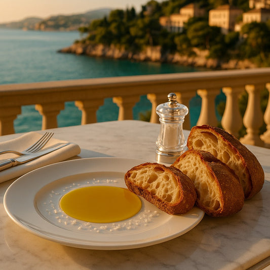 Oligri Bio Olivenöl Nativ Extra mit frischem Brot und Meersalz auf einem Balkon mit Blick auf das Mittelmeer.